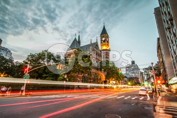 Jefferson Market Library with cars in motion blur streaks on 6th Ave in Greenwich Village in early evening - famous clock tower
