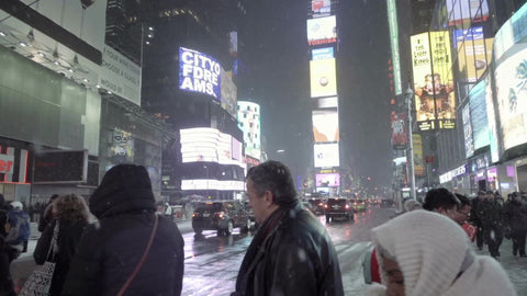 busy winter night in Times Square, snowing on traffic officer and tourists - NYC