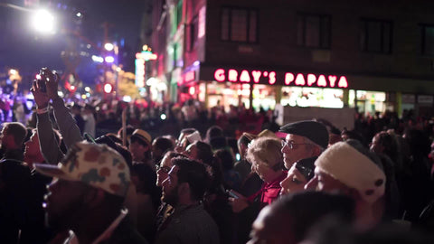 people on 6th ave and 8th street - crowd at Halloween parade with Gray's Papaya