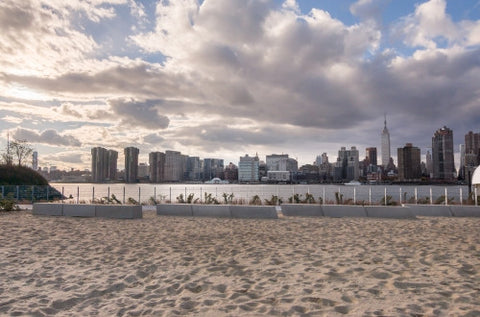 Manhattan skyline from sand - beach in Brooklyn with beautiful blue sky and clouds on summer day
