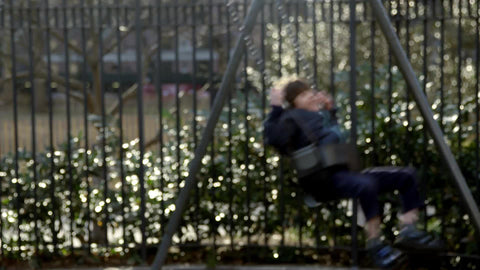 medium shot of kids swinging on swings in playground, children playing in slow motion in Washington Square Park in 4K and 1080 HD in NYC