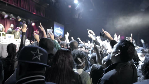 crowd with hands and arms in the air enjoying hip hop music concert - rap fans standing