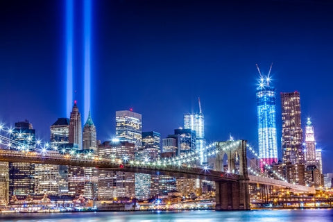 Brooklyn Bridge and Freedom Tower at night with 911 beams over city skyline - September 11th memorial lights