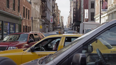 taxi cab stuck in gridlocked traffic on Lower East Side of Manhattan on summer day