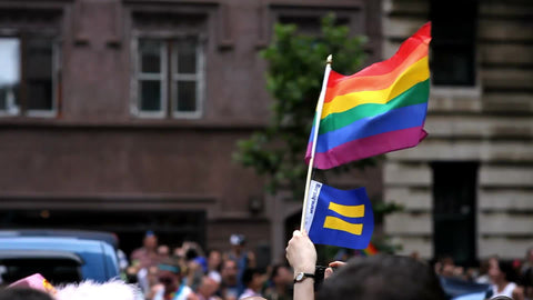 gay pride flag waving and LGBT float in parade in NYC