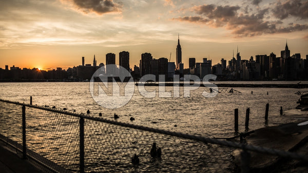 Manhattan skyline silhouette view from across East River with fence