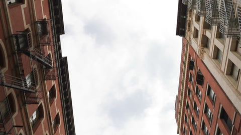 red SoHo buildings and quiet cobblestone street with cars parked in NYC