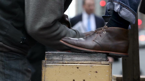shoeshiner shining brown boots on street - close-up in NYC