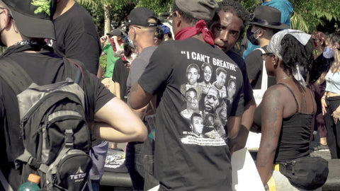 Black men speaking at BLM rally in audience at Washington Square Park in New York City