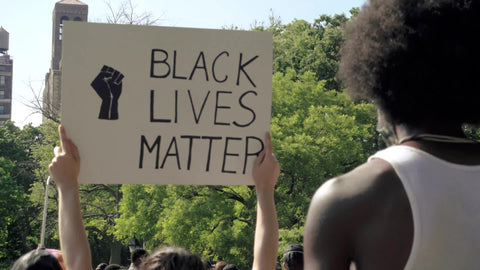 African American man with afro and Black Lives Matter sign with fist at BLM rally in New York City