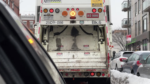 garbage truck moving slowly with pov of driver stuck behind in winter New York City NYC