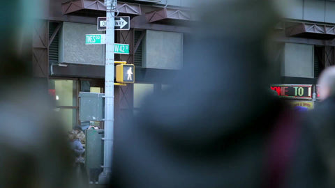 busy corner of 42nd street and Times Square in winter - people walking on crowded street