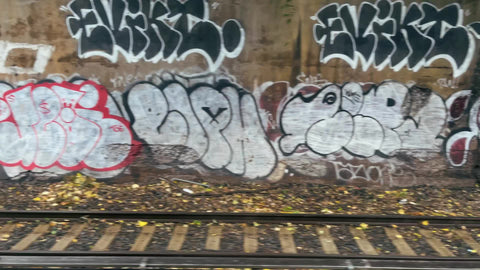 double row of graffiti pieces over B train tracks on subway ride in Brooklyn New York City