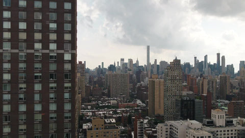 aerial of Manhattan cityscape passing building in foreground in New York City