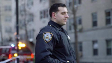 NYPD police officer at crime scene with fire truck in background - closeup in 1080 HD and 4K NYC