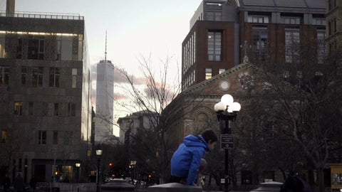 boy in Washington Square Park with view of Freedom Tower on cold winter day