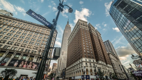 Empire State Building view from Broadway on street corner - bright sunny day in Herald Square and 34th st