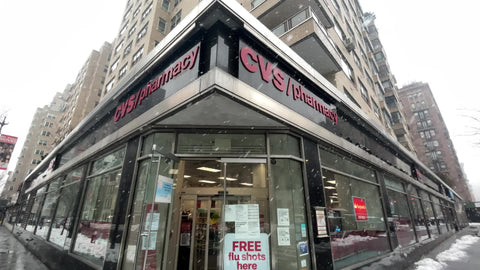 CVS store front with free flu shot sign in blizzard snowing in Manhattan New York City NYC