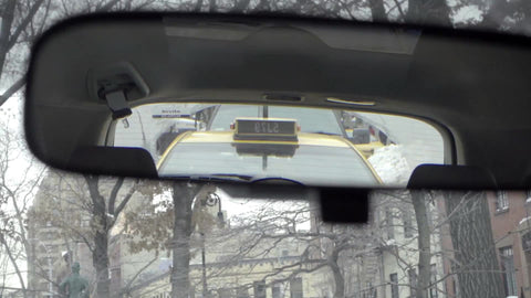 driver pov rearview mirror with taxi cab in rear, NYC