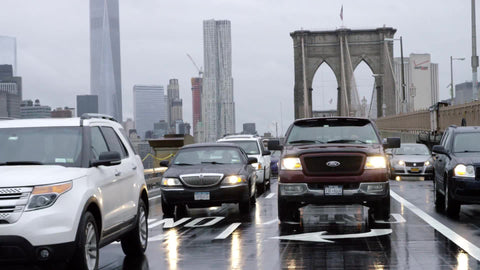 truck and cars entering Brooklyn from Bridge with Freedom Tower in background