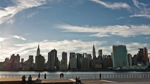 silhouettes of people enjoying Manhattan skyline from Long Island City across East River in NYC