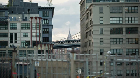 Empire State Building and Manhattan Bridge view between buildings from Brooklyn Bridge in NYC
