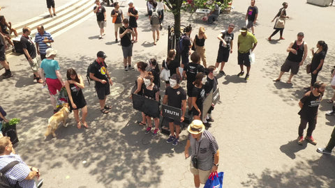 Anonymous protestors holding truth signs at protest demonstration in Union Square Park New York City