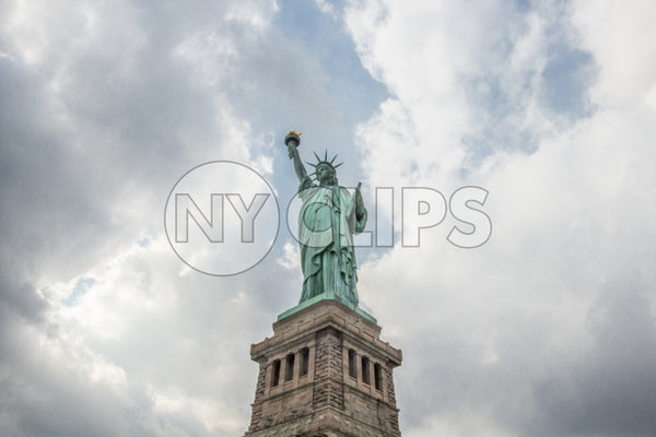Statue of Liberty - full view - blessed blue sky and light beaming through clouds on summer day