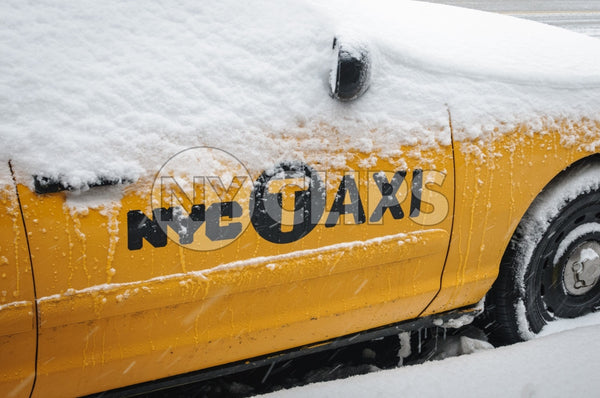 taxicab covered in snow - snowing in winter blizzard