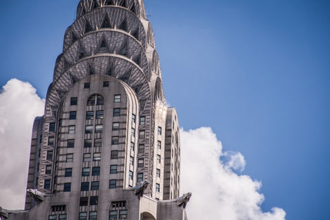tight shot of top of Chrysler Building famous Art Deco style skyscraper with blue sky on summer day in Manhattan NYC