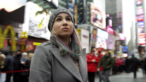 pretty tourist in coat and hat overwhelmed by Times Square on cold winter day in 4K and 1080 HD in NYC