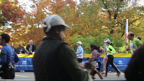 tracking shot of marathon runners running final mile with spectators watching in Central Park Manhattan in NYC