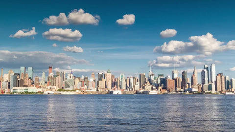 Midtown Manhattan skyline skyscrapers pulling out slowly - day to night timelapse across East River water - fast sunset in 1080 and 4K NYC