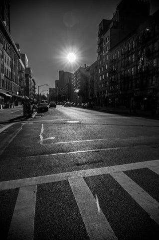 sunny day in Harlem - black and white crosswalk and bright sun shining on street