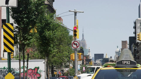 truck turning corner on Houston Street - back of taxi cab with Empire State Building in view