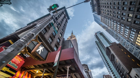 Fifth Avenue with walk sign and upward angle of Empire State Building in early evening, Manhattan NYC