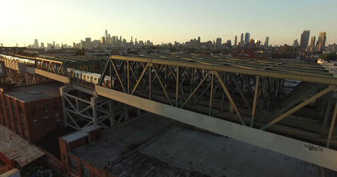 subway trains on bridge Manhattan skyline NYC