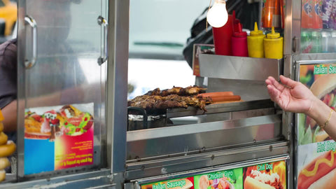 street food - hand taking change - cash exchange - woman at shish kabob food cart on summer day in NYC