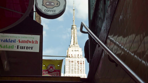 Empire State Building view coming out of 34th street subway station stairs on sunny day