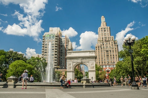 Washington Square Park in summer with fountain spraying water and famous arch, people enjoying beautiful weather