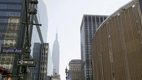 8th Ave and Madison Square Garden with Empire State Building in background in Manhattan NYC