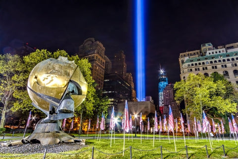 Battery Park 911 memorial beams with American flags at night