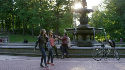 women walking by Bethesda statue and bicycles on sunny Central Park day in summer