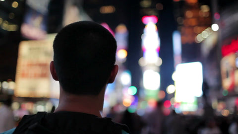 tourist looking around and taking picture in Times Square at night in New York City
