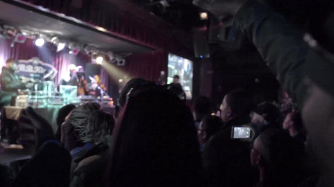 closeup of fans in crowd cheering - standing in concert - watching hip hop music show interior venue