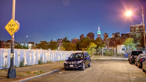 dead end sign in Brooklyn with Empire State Building and skyline in background at night in NYC