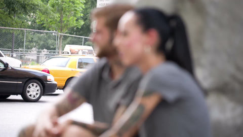 couple with tattoos smoking cigarette on summer day in NYC