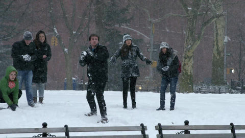 man throwing snowball over benches in winter blizzard snow storm in Washington Square Park slow motion 4K