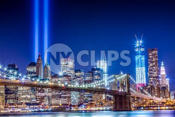 Brooklyn Bridge and Freedom Tower at night with 911 beams over city skyline - September 11th memorial lights