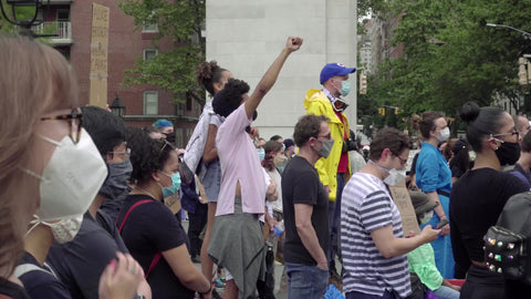 Black man holding up fist at BLM rally among allies in New York City NYC